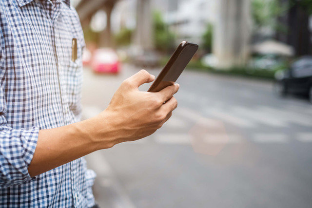 Man uses a rideshare app on his phone in Florida.